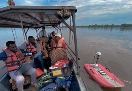 Annual Survey of Ruki River Uses ADCP to Help Gather Accurate Discharge Measurements researchers on boat